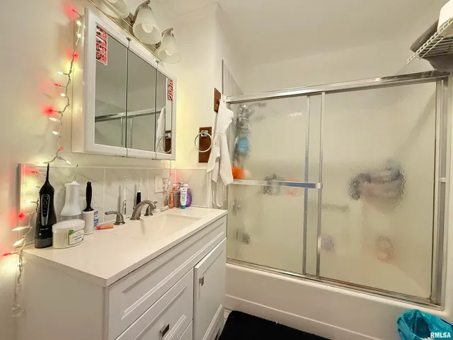 a bathroom with a sink vanity mirror and shower