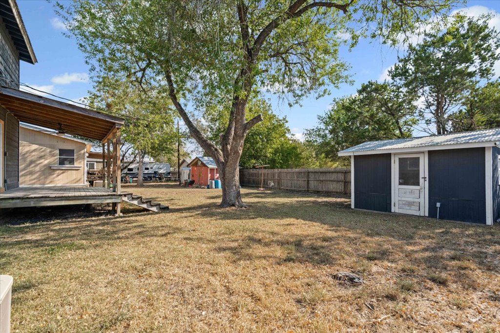 205 Cisneros Street Kyle, TX 78640 - Photo 14 of 17 Fenced backyard with a storage unit