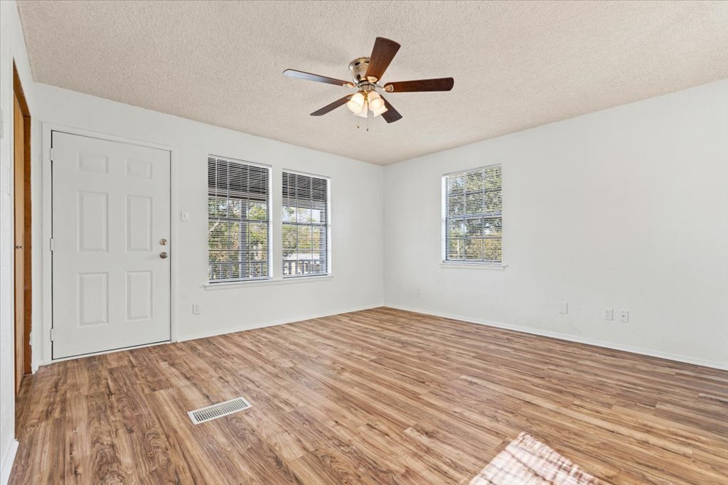 205 Cisneros Street Kyle, TX 78640 - Photo 8 of 17 Spare room featuring light wood-style flooring, a textured ceiling, and ceiling fan