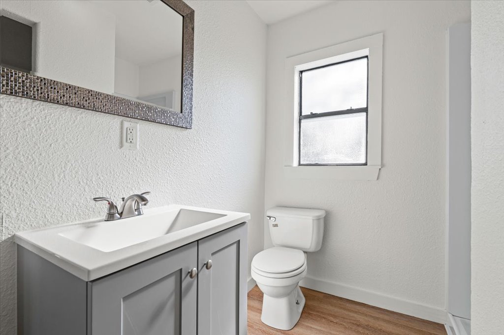 205 Cisneros Street Kyle, TX 78640 - Photo 10 of 17 Bathroom with a textured wall, light wood-style flooring, and vanity