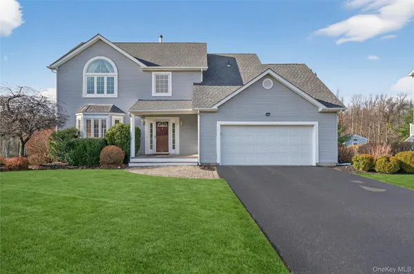 a front view of a house with a garden and garage