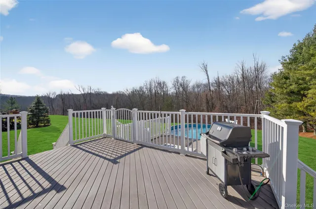 a view of a house with a barbeque and wooden stairs