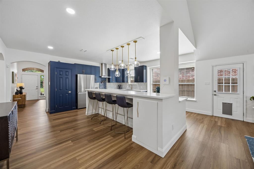 9217 Inverness Drive Rowlett, TX 75089 - Photo 6 of 40 Redesigned Kitchen Connection — The updated kitchen opens beautifully to the main living areas, blending sleek finishes, generous counter space, and a breakfast bar designed for easy conversation.