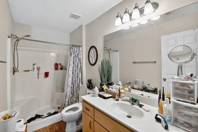 a bathroom with a sink vanity mirror and toilet