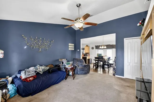 a living room with furniture a dining table and a chandelier