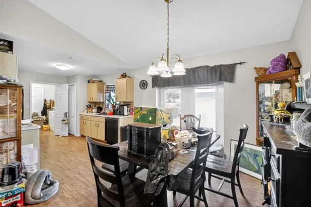 a view of a dining room and livingroom with furniture wooden floor a chandelier