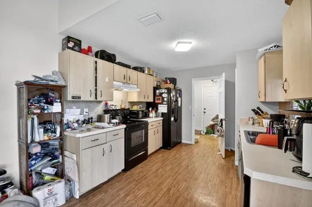 a kitchen with a sink stove and wooden cabinets