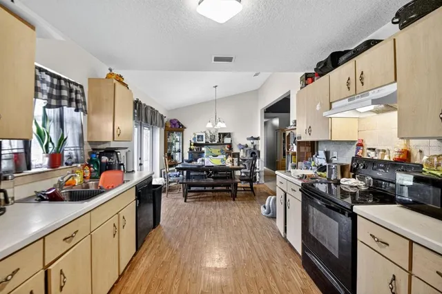 a kitchen filled with stainless steel appliances a stove a sink and a refrigerator