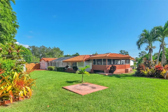 a view of a house with a yard table and chairs