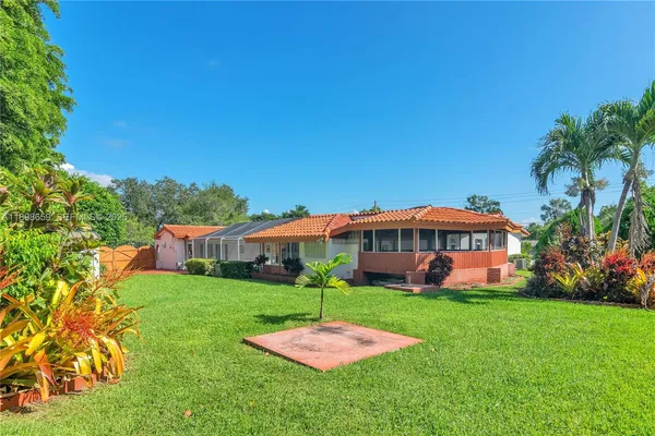 a view of a house with a yard table and chairs