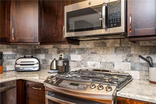 a kitchen with stainless steel appliances granite countertop a stove and a microwave