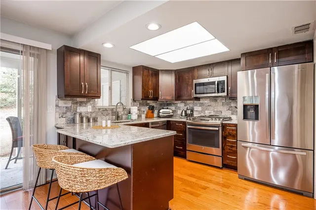 a kitchen with stainless steel appliances granite countertop a stove refrigerator sink and cabinets