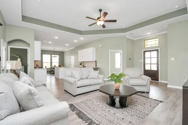 a living room with furniture a chandelier and a dining room