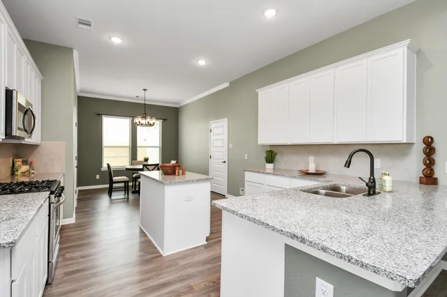 a kitchen with a sink a stove and cabinets