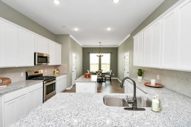a kitchen with sink a stove and cabinets