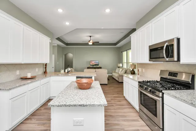 a kitchen with sink a microwave and cabinets