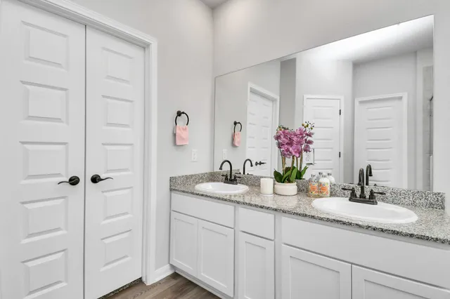 a bathroom with a granite countertop tub sink and mirror