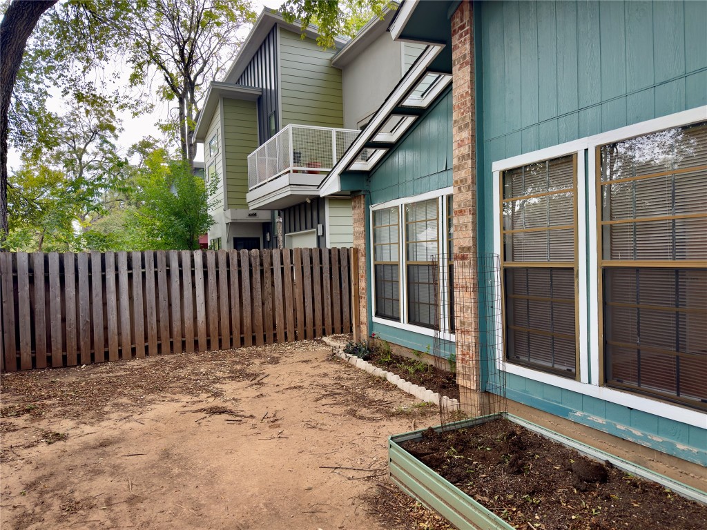 115 Waller Street, Unit A Austin, TX 78702 - Photo 17 of 18 View of side of property with a fenced backyard, a vegetable garden, and a balcony