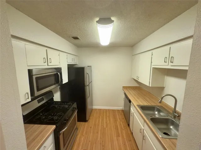 a kitchen with a sink a stove and refrigerator