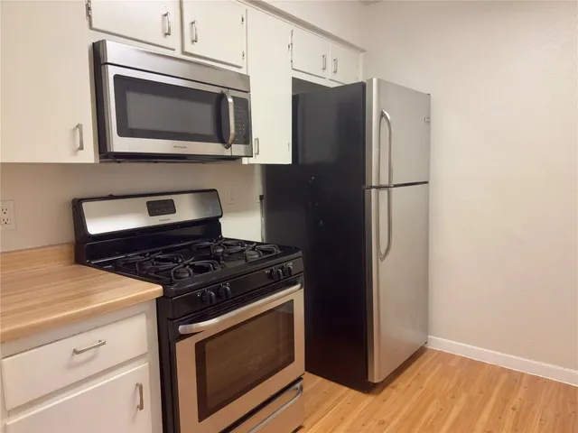 a kitchen with granite countertop cabinets and steel stainless steel appliances