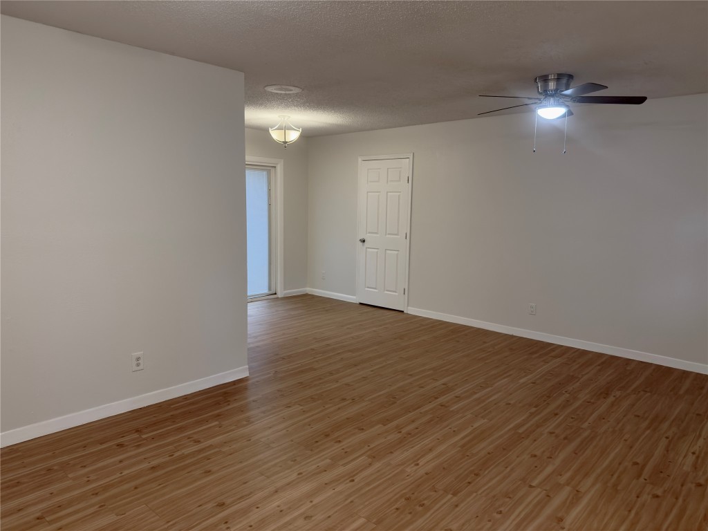 115 Waller Street, Unit A Austin, TX 78702 - Photo 6 of 18 Empty room with a textured ceiling, light wood finished floors, and ceiling fan