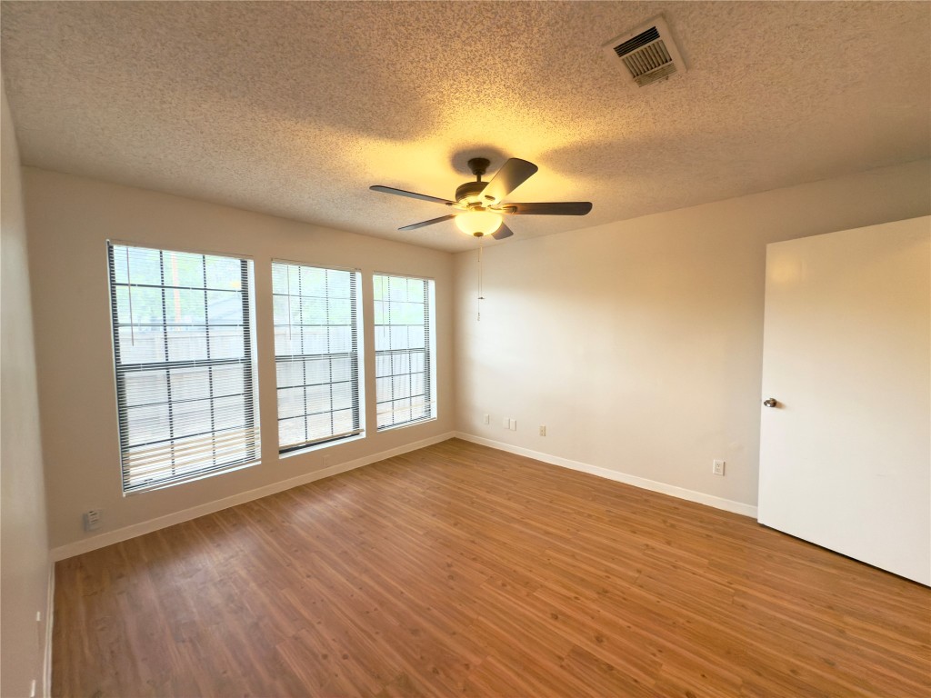 115 Waller Street, Unit A Austin, TX 78702 - Photo 7 of 18 Unfurnished room featuring light wood finished floors, a textured ceiling, and ceiling fan