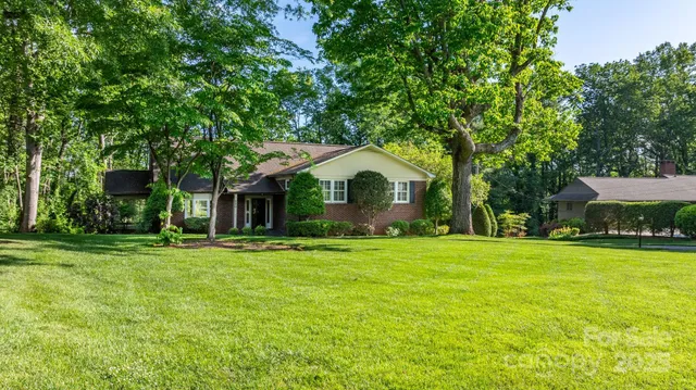 a front view of a house with a yard and trees