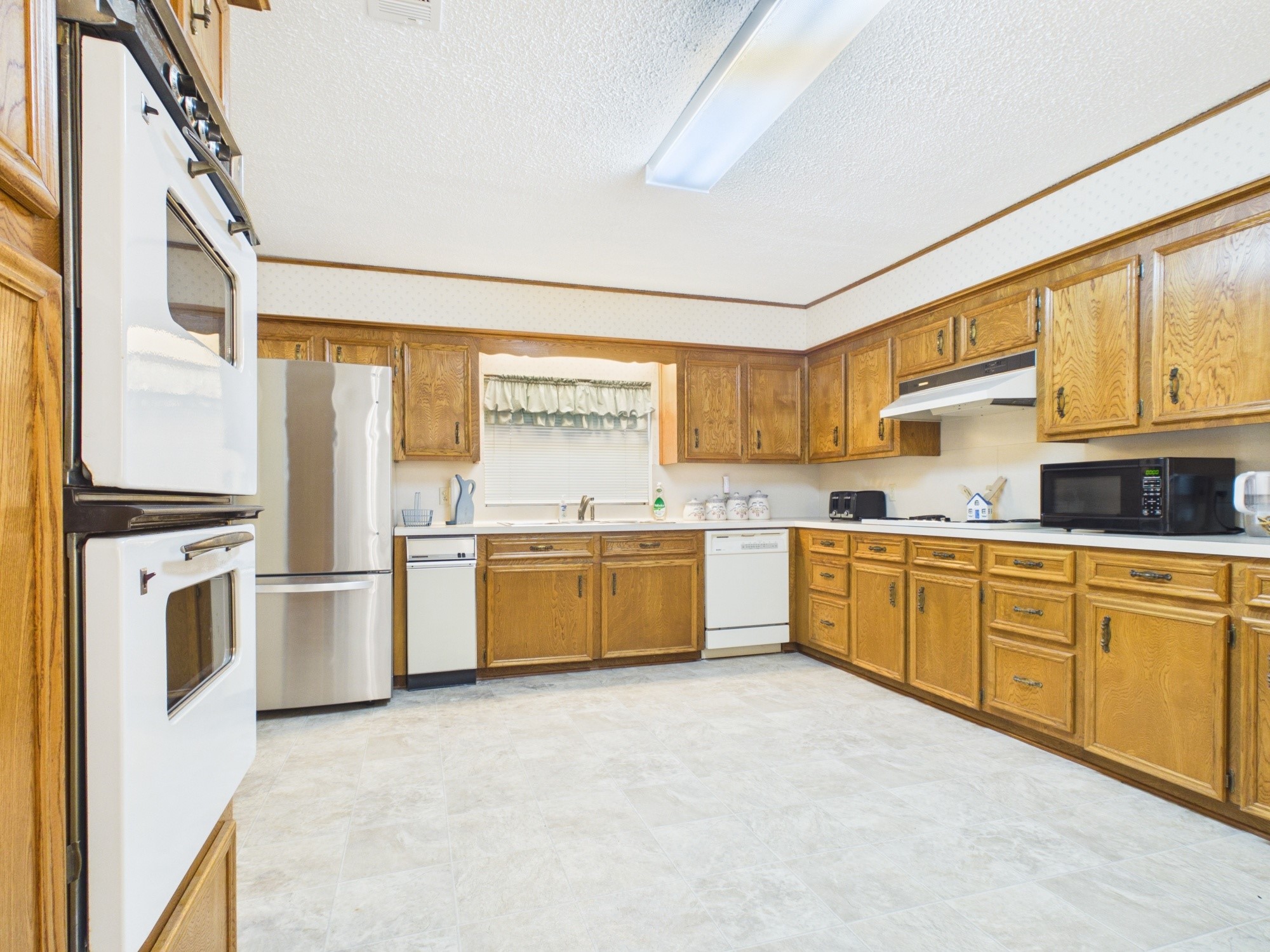 12 Harding Road Huntsville, TX 77340 - Photo 11 of 20 a kitchen with a stove top oven sink and a refrigerator