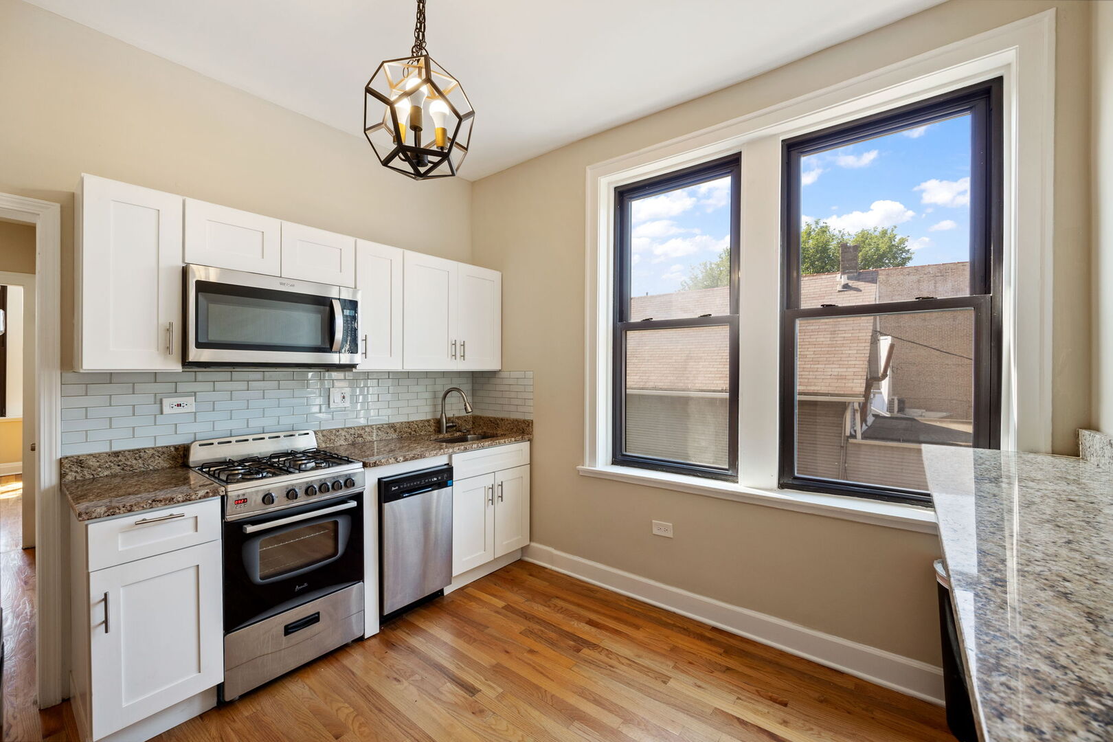 2242 North Western Avenue, Unit 2F Chicago, IL 60647 - Photo 7 of 12 a kitchen with stainless steel appliances granite countertop a stove and a microwave