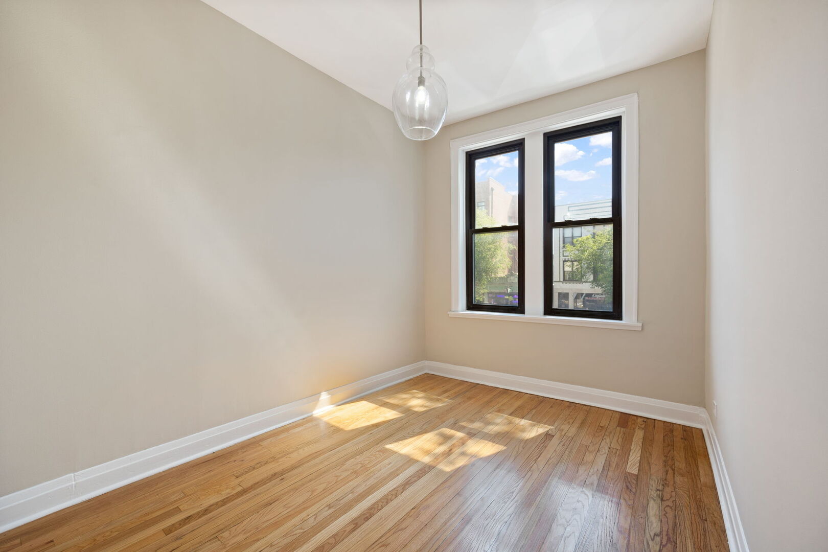 2242 North Western Avenue, Unit 2F Chicago, IL 60647 - Photo 8 of 12 an empty room with wooden floor and windows