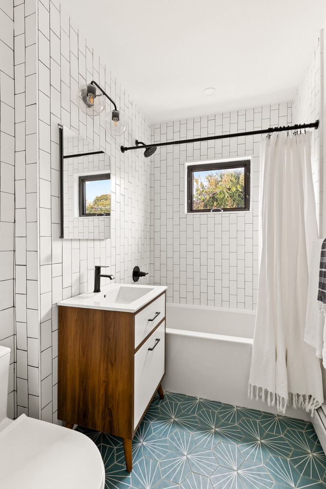 13 Reeve Place Brooklyn, NY 11218 - Photo 12 of 14 a bathroom with a sink a toilet a mirror and bathtub