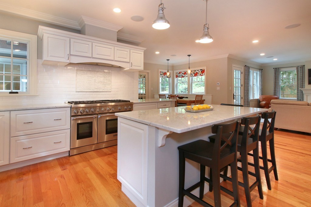 21 Cypress Road Wellesley, MA 02481 - Photo 9 of 23 a kitchen with a stove a kitchen island with chairs and wooden floor