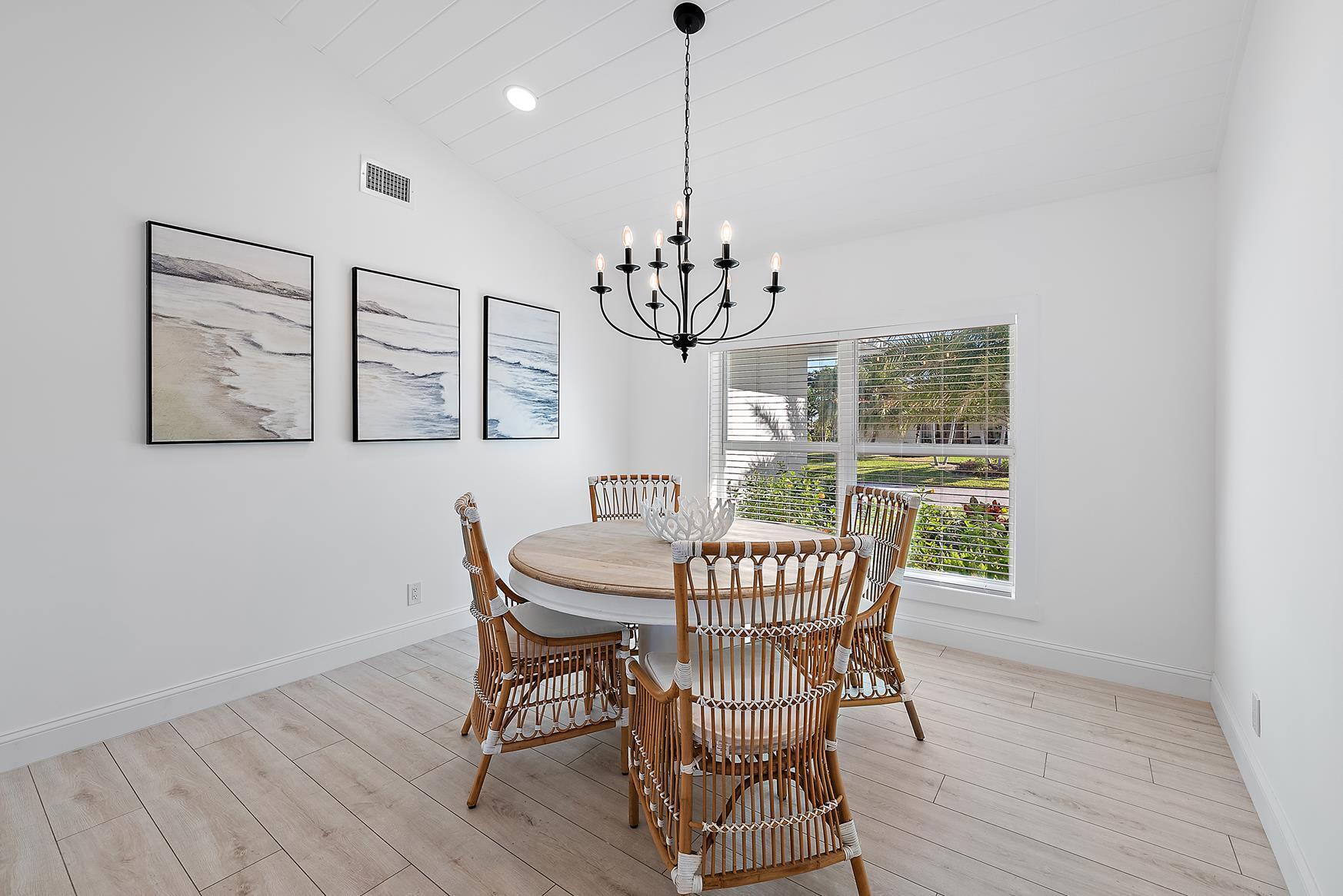 491 Sunset Way Juno Beach, FL 33408 - Photo 15 of 50 a dining room with furniture a chandelier and wooden floor