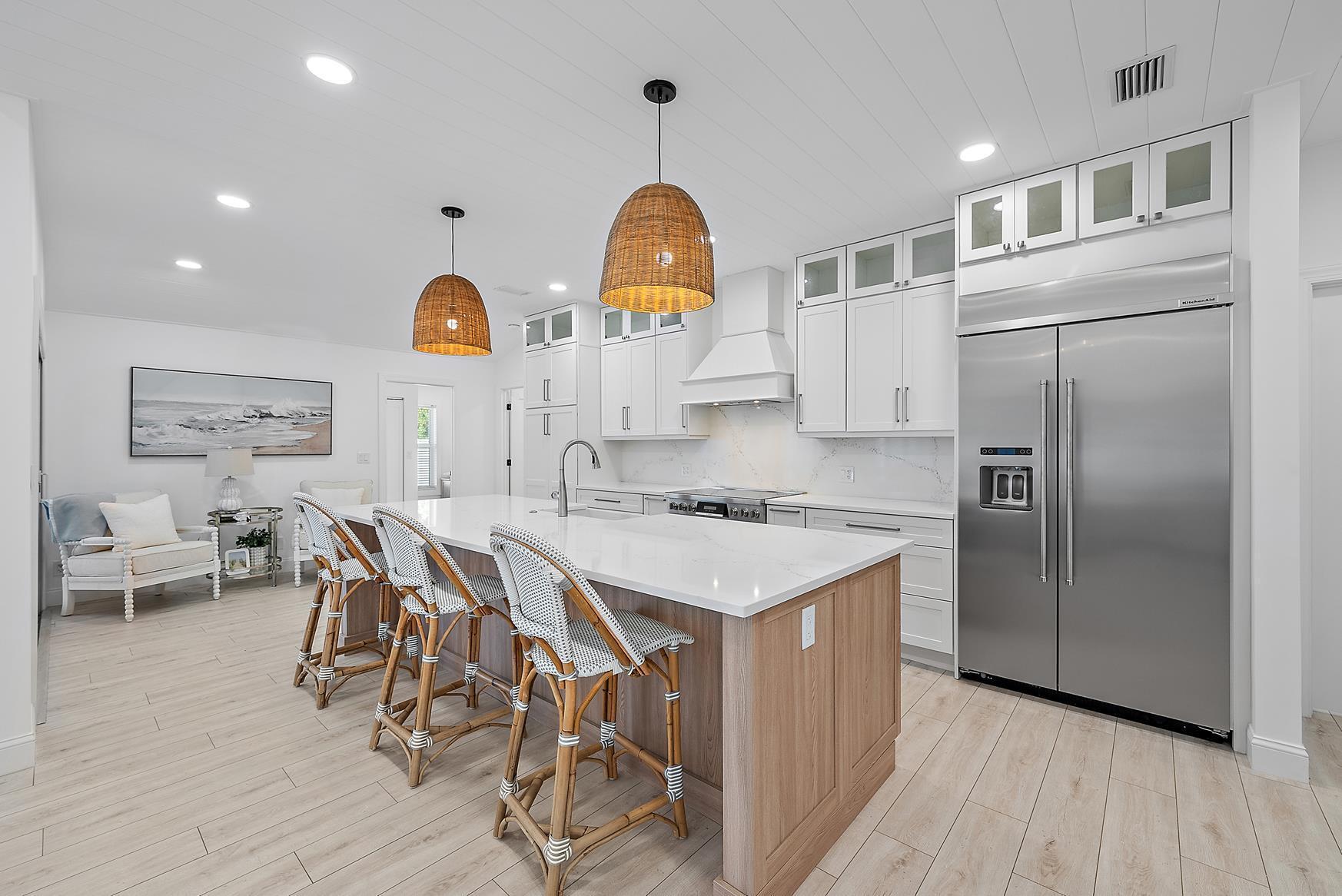 491 Sunset Way Juno Beach, FL 33408 - Photo 16 of 50 a kitchen with stainless steel appliances a stove a sink a refrigerator and cabinets