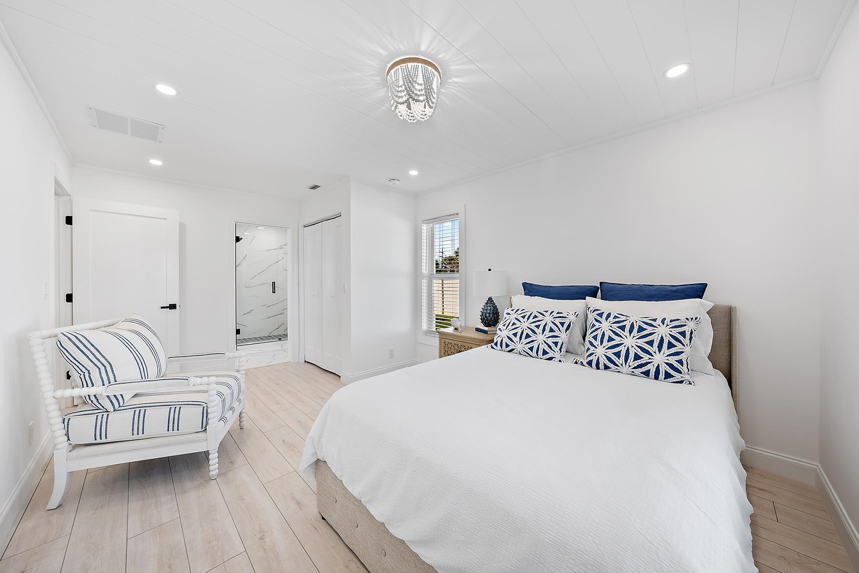 491 Sunset Way Juno Beach, FL 33408 - Photo 27 of 50 a spacious bedroom with a bed and a couch