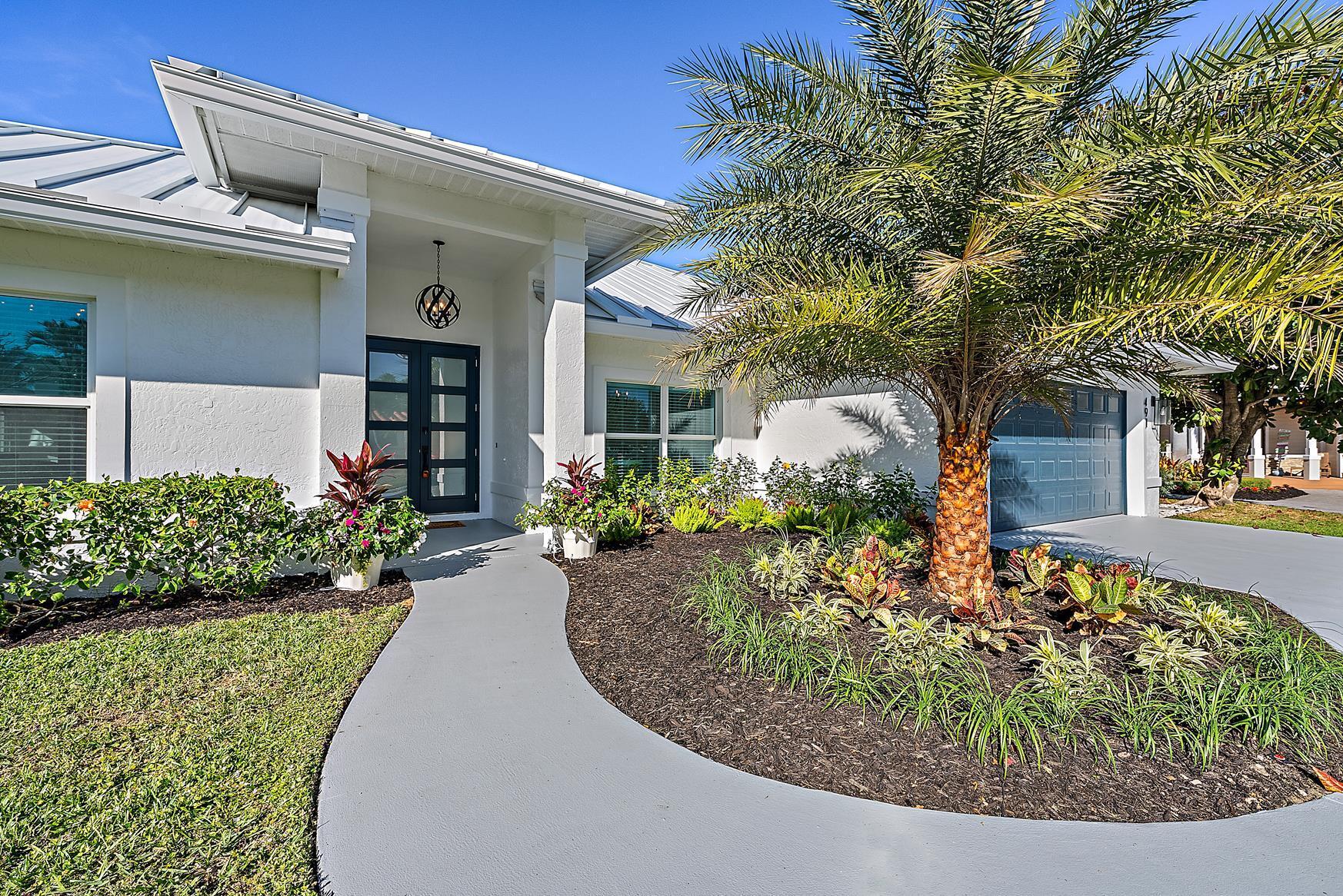 491 Sunset Way Juno Beach, FL 33408 - Photo 4 of 50 a front view of a house with garden