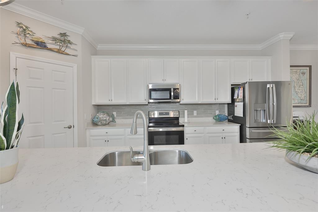 12405 Ghiberti Circle, Unit 202 Venice, FL 34293 - Photo 15 of 35 a kitchen with stainless steel appliances a microwave a stove and white cabinets