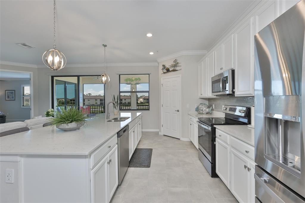12405 Ghiberti Circle, Unit 202 Venice, FL 34293 - Photo 16 of 35 a kitchen with granite countertop a sink stove and refrigerator