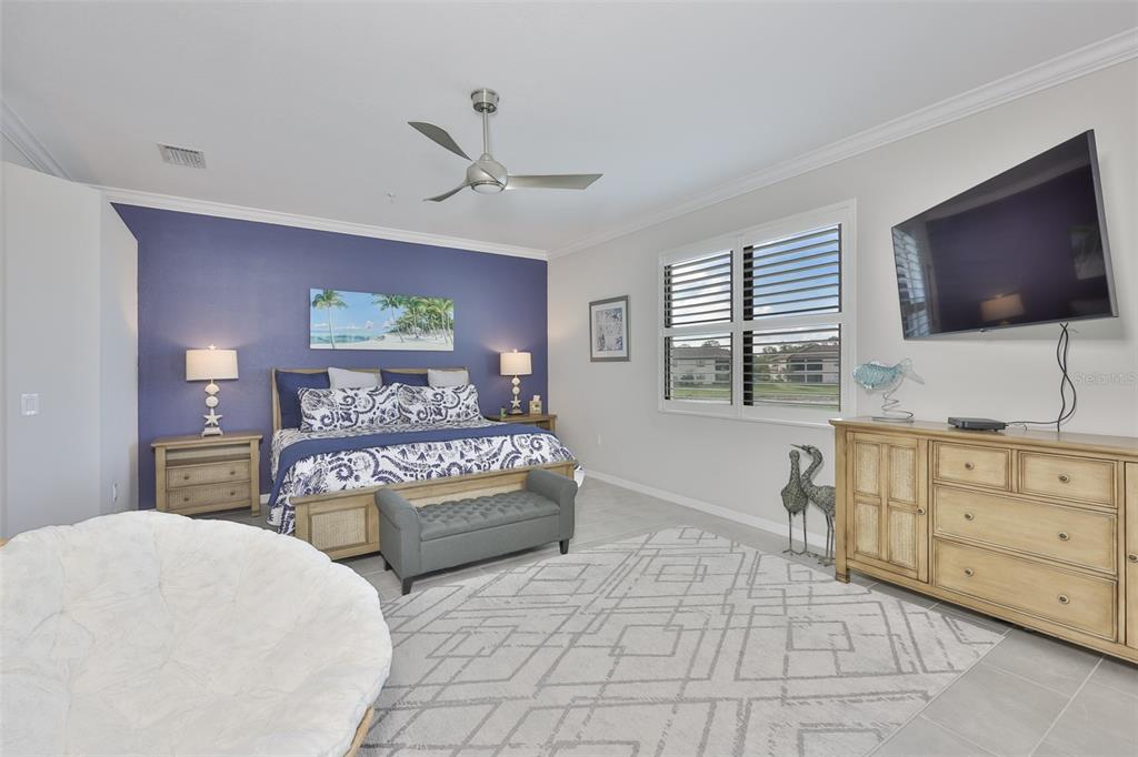 12405 Ghiberti Circle, Unit 202 Venice, FL 34293 - Photo 21 of 35 a bedroom with a large bed and a flat screen tv
