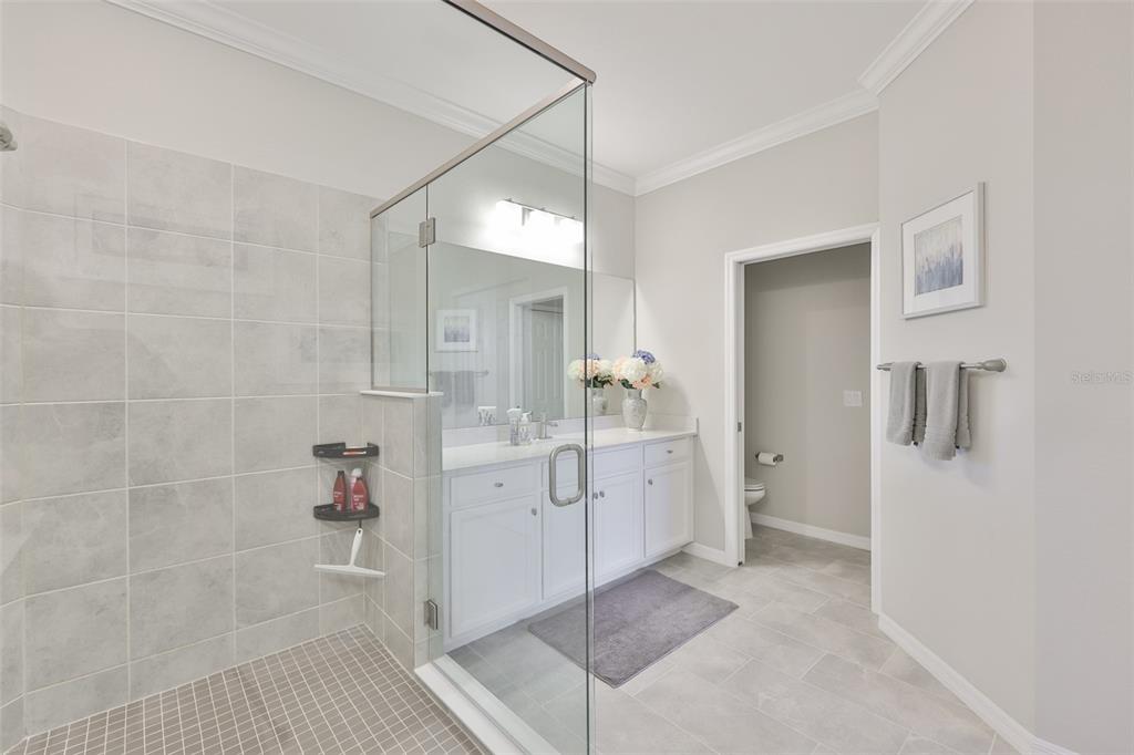 12405 Ghiberti Circle, Unit 202 Venice, FL 34293 - Photo 24 of 35 a bathroom with a double vanity sink a mirror and shower