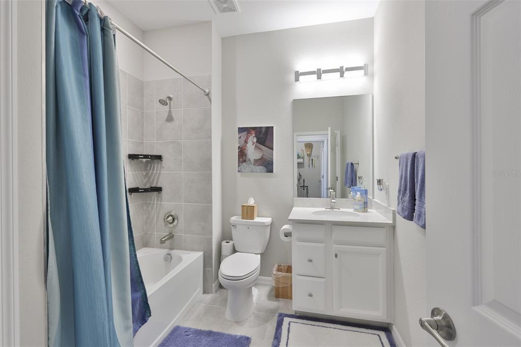 12405 Ghiberti Circle, Unit 202 Venice, FL 34293 - Photo 27 of 35 a bathroom with a sink a toilet a large mirror a bathtub and shower
