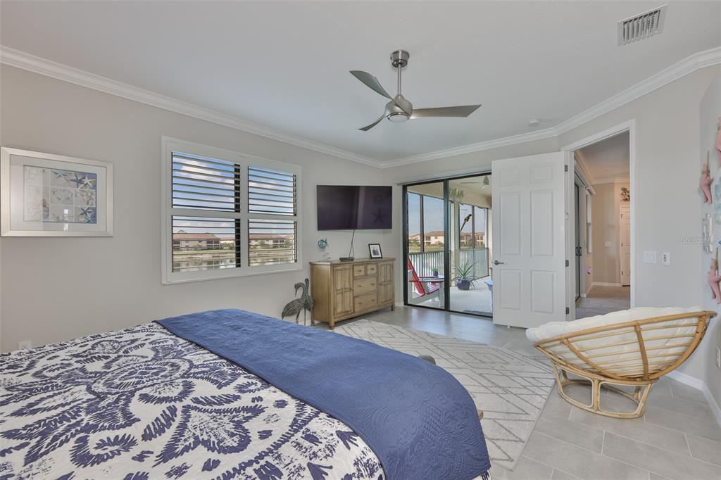 12405 Ghiberti Circle, Unit 202 Venice, FL 34293 - Photo 28 of 35 a spacious bedroom with a bed a window and a flat screen tv