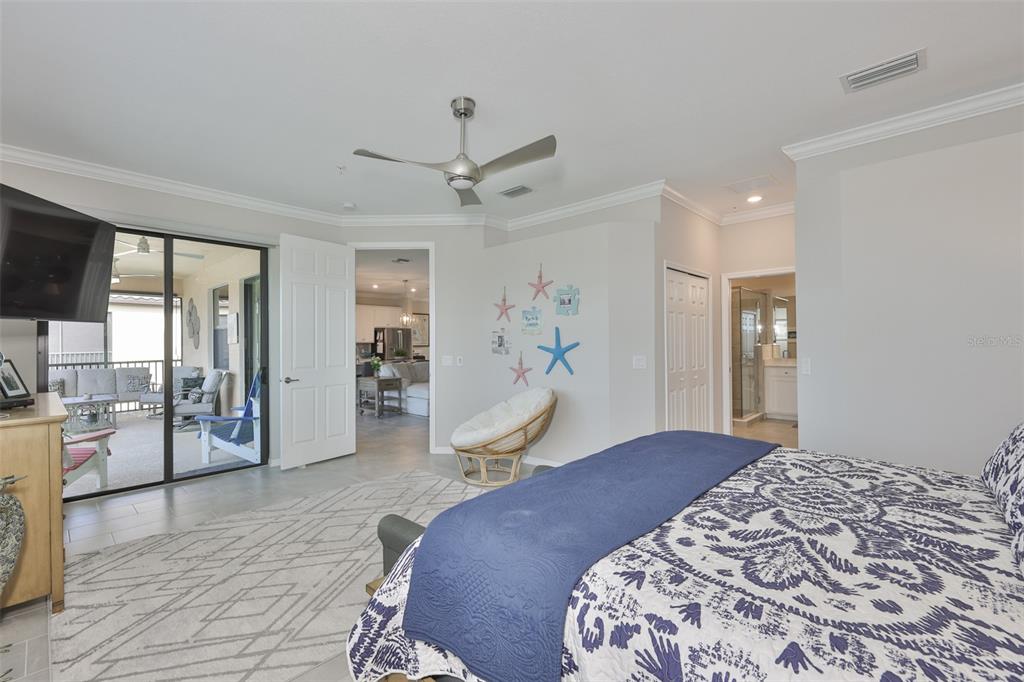 12405 Ghiberti Circle, Unit 202 Venice, FL 34293 - Photo 29 of 35 a bedroom with a large bed and a chandelier