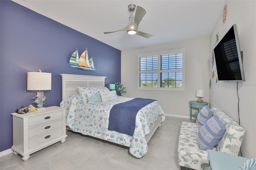 12405 Ghiberti Circle, Unit 202 Venice, FL 34293 - Photo 32 of 35 a bedroom with a bed and a flat screen tv