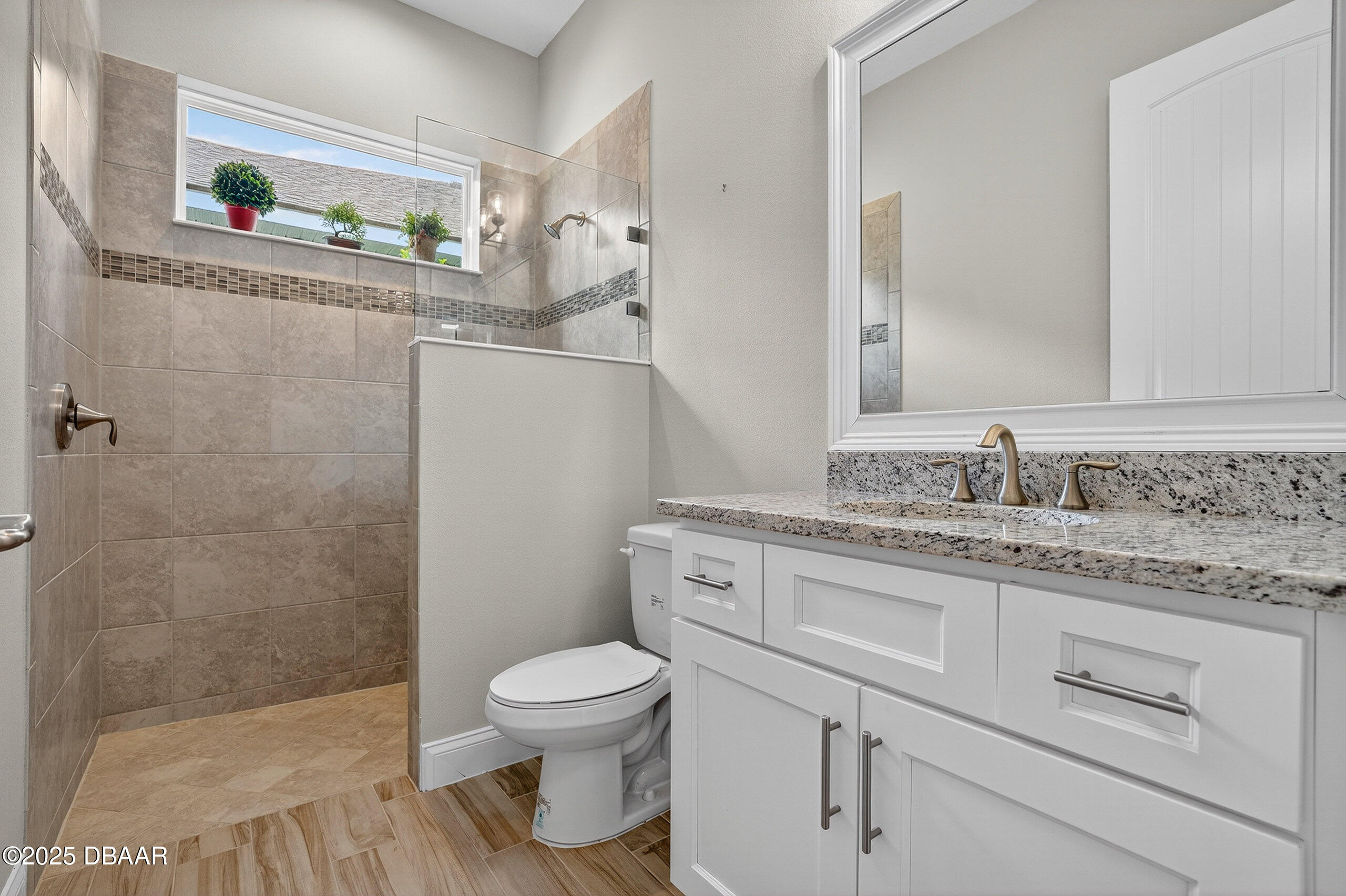 212 Fuchsia Street Daytona Beach, FL 32124 - Photo 31 of 54 a bathroom with a granite countertop sink a toilet a shower and a mirror