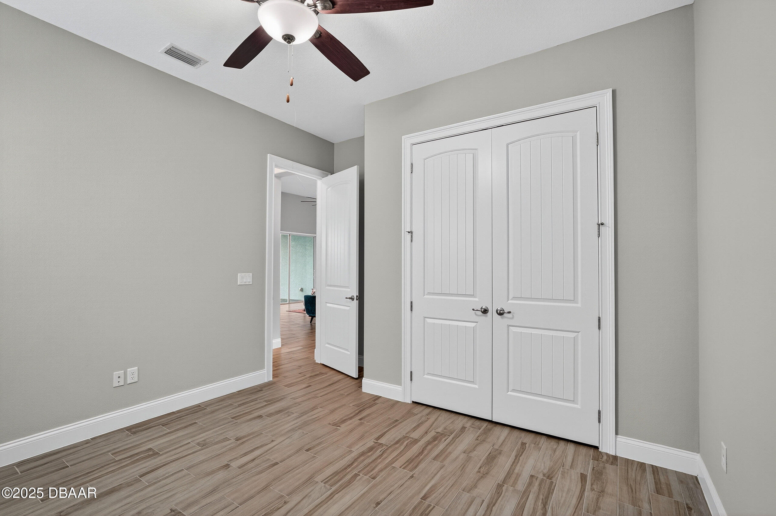 212 Fuchsia Street Daytona Beach, FL 32124 - Photo 33 of 54 an empty room with wooden floor ceiling fan and windows