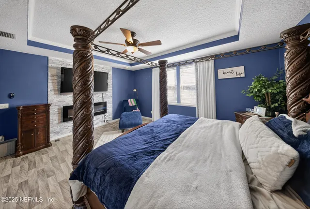 a spacious bedroom with a large bed and a chandelier
