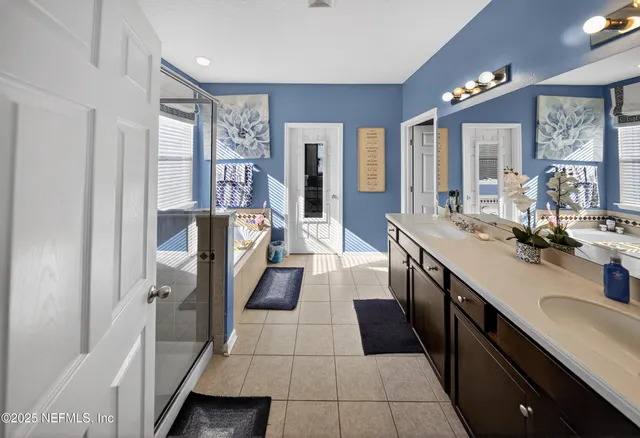 a large bathroom with a double vanity sink a mirror and a shower