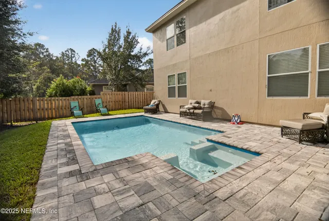 a backyard of a house with table and chairs