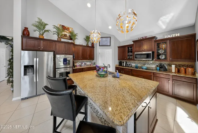 a kitchen with stainless steel appliances granite countertop a sink refrigerator and microwave